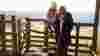Mother and child sitting on a countryside wooden gate
