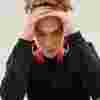 Teenage boy with headphones around his neck, with his head in his hands.