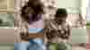 Mum with her arms around her son who has his arms folded angrily