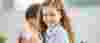 Primary aged girl with curly hair smiles into the camera