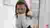 Girl with long hair sitting down with her head in her hands